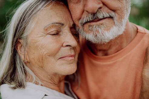 Porträt eines verliebten älteren Paares, das im Freien in der Natur steht. - HPIF03733