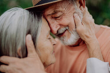 Portrait of senior couple in love, standing and hugging outdoor in the nature. - HPIF03742