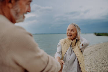 Happy senior couple relaxing and having romantic moment at the autumn sea. - HPIF03747