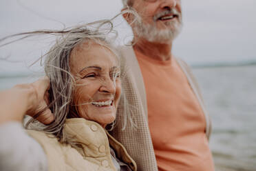 Glückliches älteres Paar entspannt sich und hat einen romantischen Moment am herbstlichen Meer. - HPIF03749