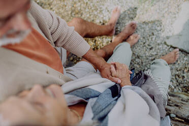 Ein älteres Paar entspannt sich und hat einen romantischen Moment am herbstlichen Meer. - HPIF03752