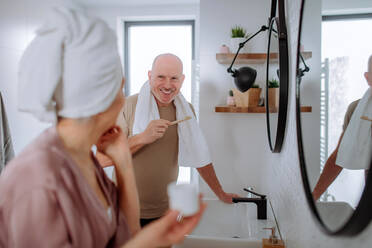 Ein älteres Ehepaar im Badezimmer, Zähneputzen und Waschen, Konzept der Morgenroutine. - HPIF03831