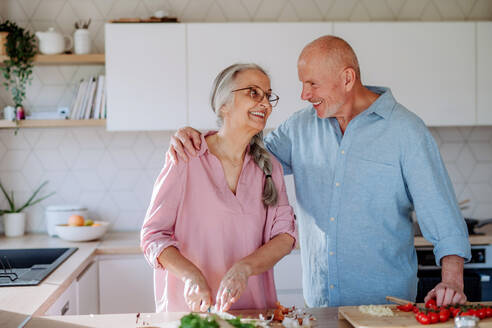 Ein älteres Ehepaar kocht gemeinsam zu Hause. - HPIF03869