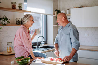 Ein älteres Ehepaar kocht gemeinsam zu Hause. - HPIF03870