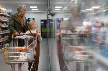 Eine Großmutter kauft mit ihrer Enkelin Lebensmittel im Supermarkt. - HPIF04022