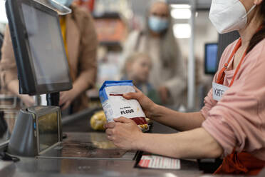 A checkout counter hands of the cashier scans groceries in supermarket. - HPIF04033