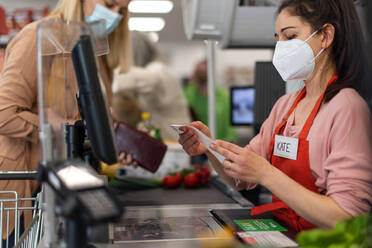 Eine Kassiererin, die nach einer Kundenbeschwerde im Supermarkt den Kassenzettel ausfüllt, - HPIF04036