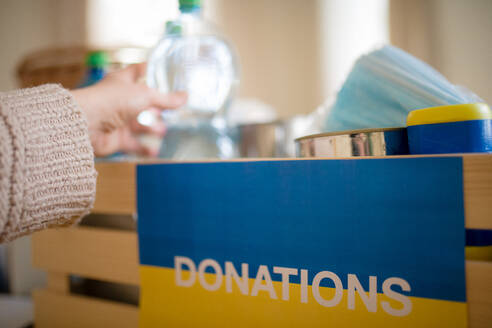 Eine Nahaufnahme einer Kiste mit Hilfsgütern für ukrainische Flüchtlinge. Konzept der humanitären Hilfe. - HPIF04057