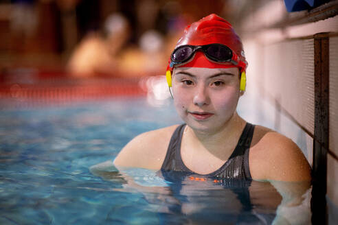 Eine junge Frau mit Down-Syndrom im Schwimmbad schaut in die Kamera - HPIF04085