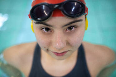 Eine junge Frau mit Down-Syndrom im Schwimmbad schaut in die Kamera - HPIF04089