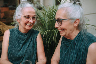 Glückliche ältere Frauen, die in der Stadt eine Kaffeepause machen, lächeln und sich unterhalten. - HPIF04162