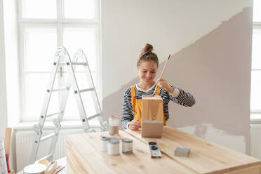 Glückliche junge Frau, die ein Regal in ihrem Haus neu einrichtet. Konzept der Wiederverwendung von Materialien und des nachhaltigen Lebensstils. - HPIF04197