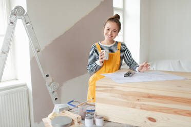 Happy young woman remaking wooden cabinet in her house. Concept of reusing materials and sustainable lifestyle. - HPIF04200