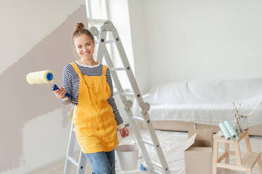 Happy young woman remaking her new house, painting walls. Concept of renovation, indepent women and sustainable lifestyle. - HPIF04274