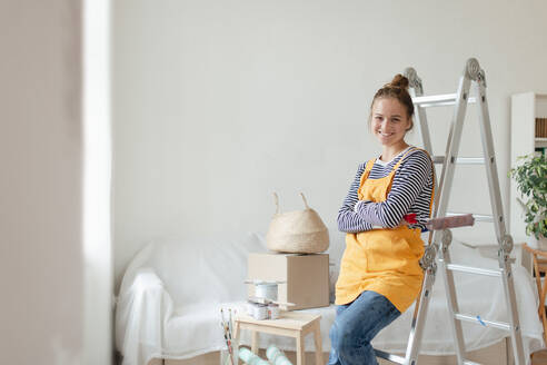 Glückliche junge Frau, die bei der Renovierung ihres Hauses eine Pause einlegt. - HPIF04283