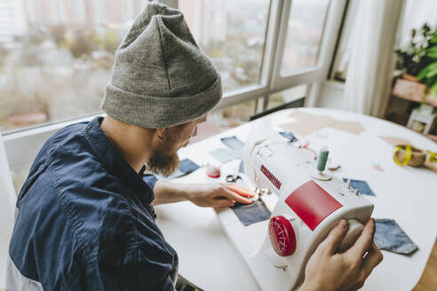 Designerin bei der Arbeit an der Nähmaschine in der Werkstatt - YTF00348