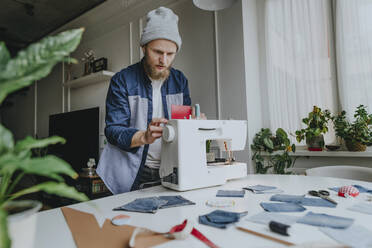 Fashion designer adjusting sewing machine in workshop - YTF00351