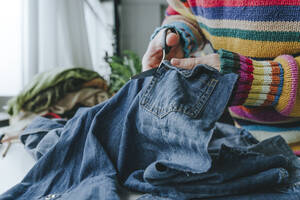 Hände eines Modedesigners beim Schneiden von Denim-Jeans - YTF00363