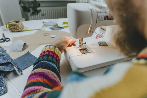 Modedesignerin beim Einstellen des Fadens in der Nähmaschine - YTF00369