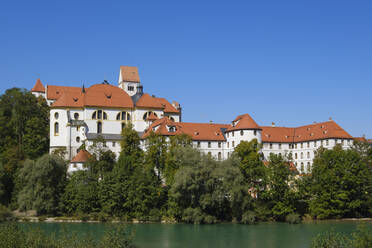 Germany, Bavaria, Fussen, Fussen Castle and St. Mangs Abbey with bank of Lech river in foreground - WIF04664