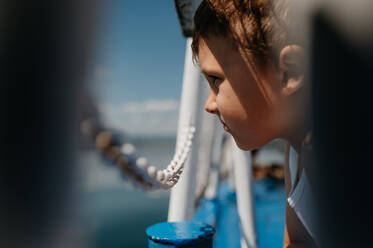 A little curious boy looking at water from motor boat. - HPIF04414