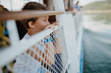 A little curious boy looking at water from motor boat. - HPIF04415