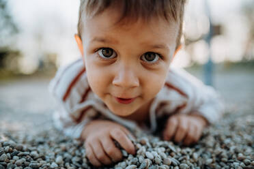 Ein kleiner Junge spielt auf einem Spielplatz im Freien. - HPIF04425