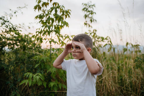 Ein kleiner Junge steht im Sommer auf dem Feld - HPIF04433