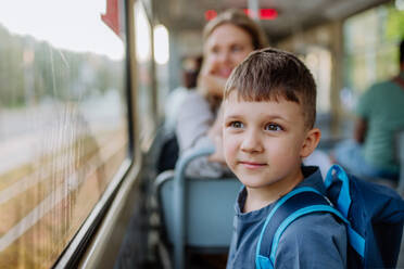 Eine Nahaufnahme eines kleinen Jungen, der morgens mit dem Bus zur Schule fährt, ein Konzept für Pendler und nachhaltigen Lebensstil. - HPIF04470