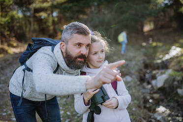 A father with small daughter with binoculars on walk in spring nature together. - HPIF04591