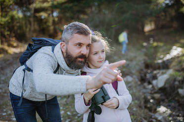 Ein Vater mit kleiner Tochter mit Fernglas auf Spaziergang im Frühling Natur zusammen. - HPIF04591