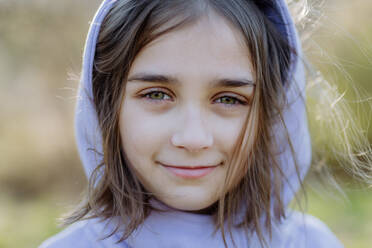 Portrait of pretty child girl standing in summer park looking in camera smiling happily. - HPIF04595