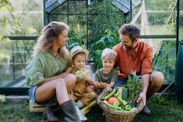 A farmer family with fresh harvest standing in a greenhouse - HPIF04849