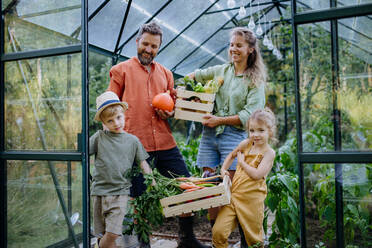 Eine Bauernfamilie mit frischer Ernte in einem Gewächshaus - HPIF04858