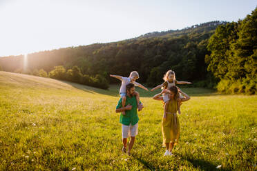 Eine glückliche junge Familie, die draußen in der grünen Natur Zeit miteinander verbringt. - HPIF04885