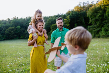 Eine glückliche junge Familie, die draußen in der grünen Natur Zeit miteinander verbringt. - HPIF04887