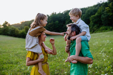 Eine glückliche junge Familie, die draußen in der grünen Natur Zeit miteinander verbringt. - HPIF04888