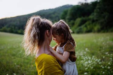 A happy mother spending time with her little daughter outside in green nature. - HPIF04910