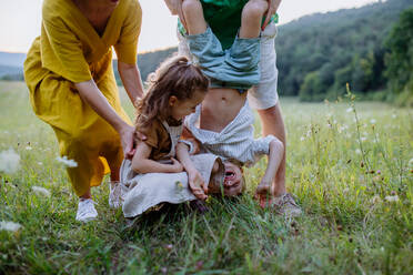 Eine glückliche junge Familie, die draußen in der grünen Natur gemeinsam Spaß hat. - HPIF04915