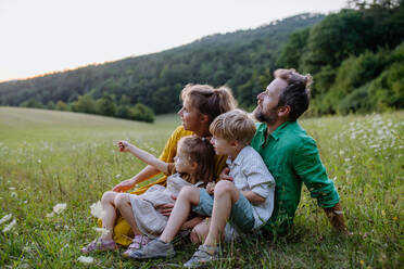 Eine glückliche junge Familie, die draußen in der grünen Natur Zeit miteinander verbringt. - HPIF04916