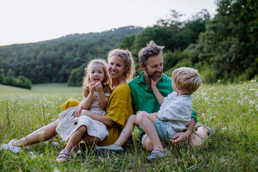 Eine glückliche junge Familie, die draußen in der grünen Natur Zeit miteinander verbringt. - HPIF04917