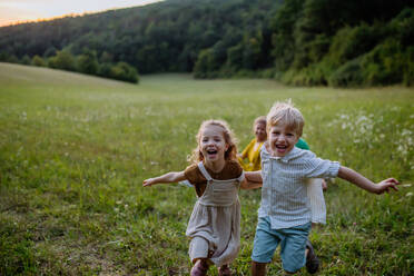 Eine glückliche junge Familie, die draußen in der grünen Natur Zeit miteinander verbringt. - HPIF04919