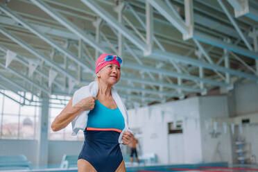 Ein niedriger Winkel Ansicht der aktiven älteren Frau preapring für schwimmen in Hallenbad. - HPIF04933
