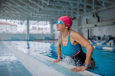 Eine glückliche ältere Frau, die das Schwimmbad verlässt. - HPIF04966