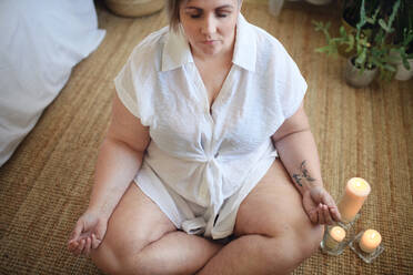 A close-up of overweight woman meditating at home. - HPIF04984