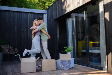 A cheerful young couple moving in their new tiny house in woods. Conception of moving and sustainable living. - HPIF05016