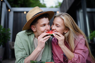 Ein fröhliches, verliebtes junges Paar isst gemeinsam ein Stück Wassermelone - HPIF05033