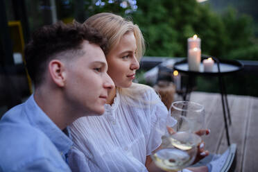 A young couple clinking with wine outdoors, weekend away in tiny house in countryside, sustainable living. - HPIF05053