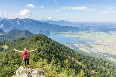 Deutschland, Bayern, Kochel am See, Wanderin steht auf Berggipfel mit Kochelsee im Hintergrund - FOF13241