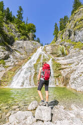 Deutschland, Bayern, Wanderin bewundert Glasbachwasserfall im Sommer - FOF13251